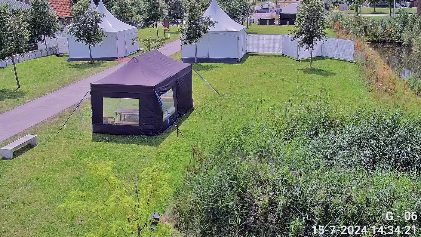Camerabeeld van tenten op een evenemententerrein onder tijdelijke camerabewaking