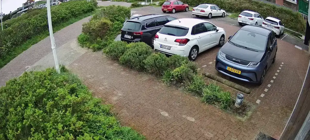 Camerabeeld van geparkeerde auto's op een terrein, gezien vanaf de paal