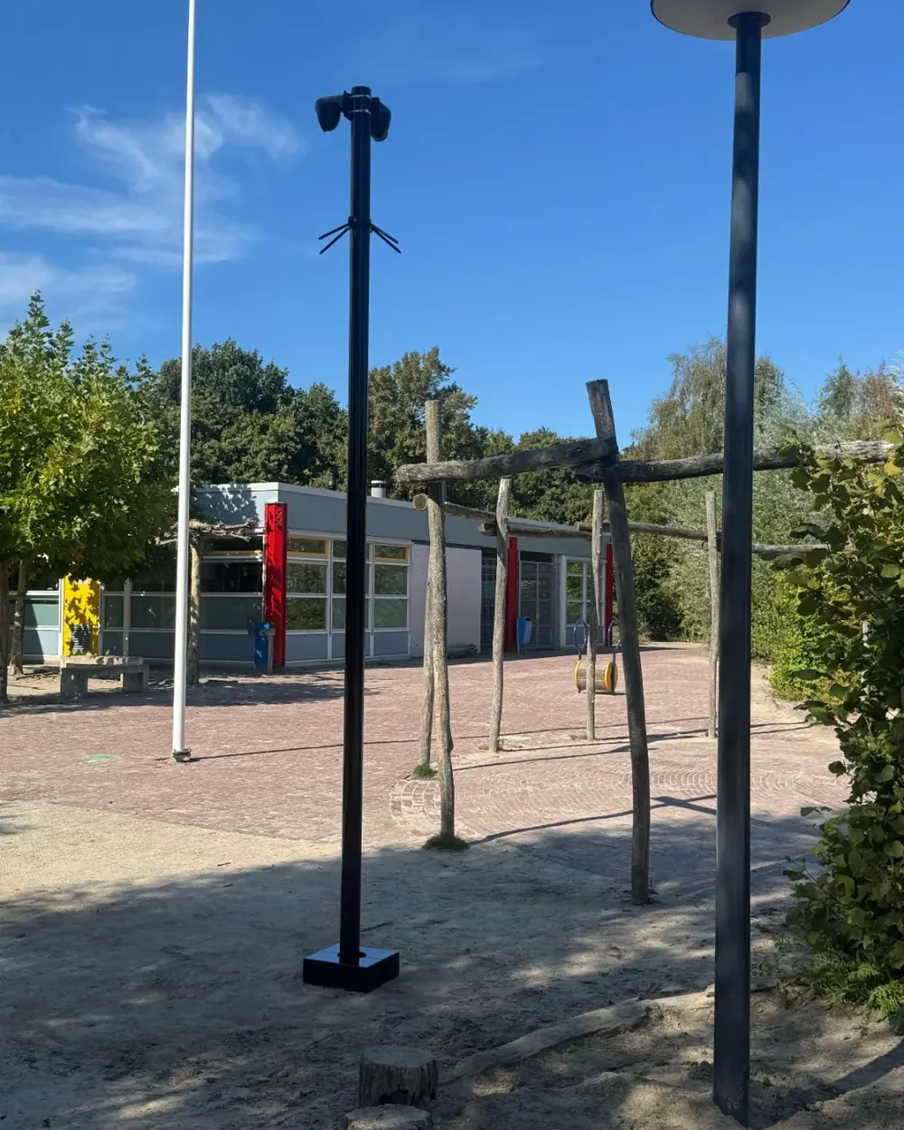 Cameramast aan de rand van een leeg plein met speeltoestellen