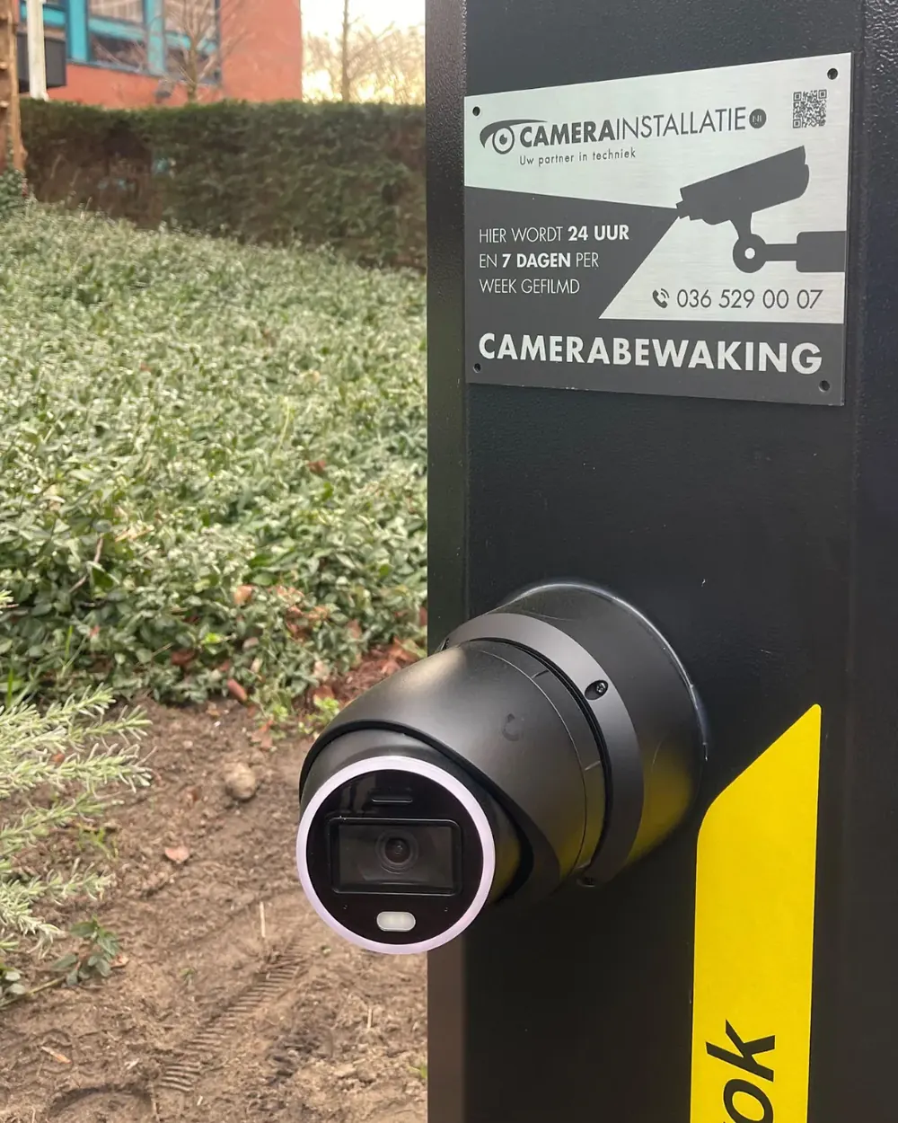 Verplaatsbare zuil met een camera erop en een bord dat camerabewaking aankondigt
